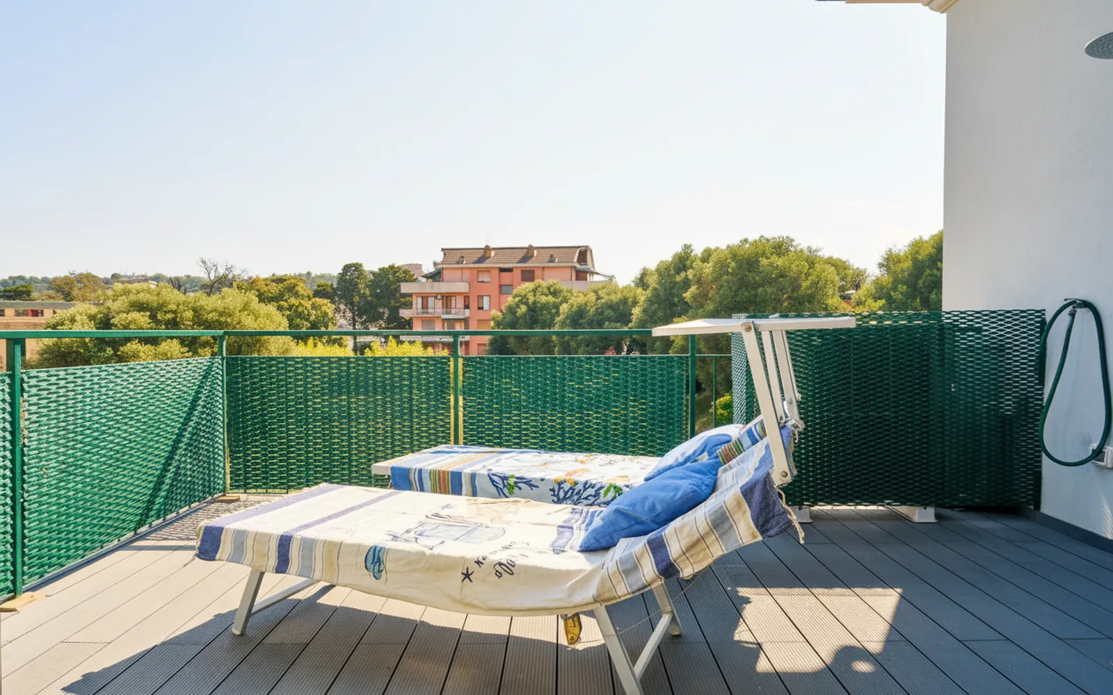 Il solarium con i lettini, tra il verde e le case